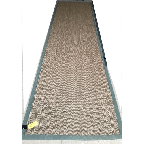 675 - A Sisal Runner rug, 488 x 121cm, with green material edging