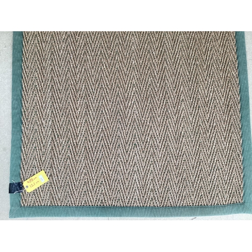 675 - A Sisal Runner rug, 488 x 121cm, with green material edging