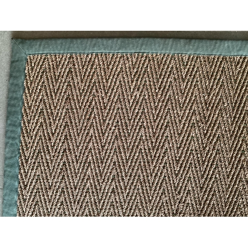 675 - A Sisal Runner rug, 488 x 121cm, with green material edging