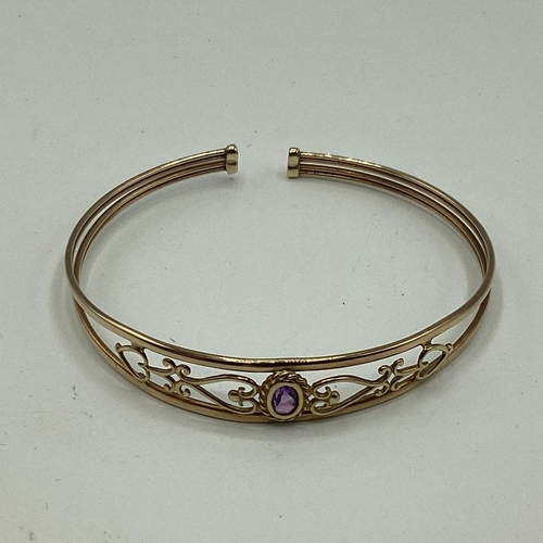 15 - A 9ct gold pierced bangle bracelet set with single amethyst together with a 9ct gold crucifix pendan... 