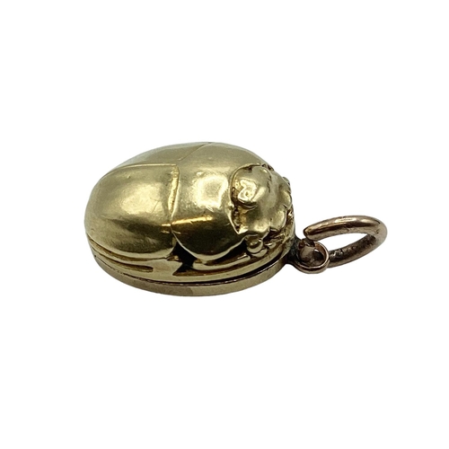 19 - An unmarked yellow metal (possibly 14ct+ gold) scarab beetle memorial locket. Opening to reveal oval... 