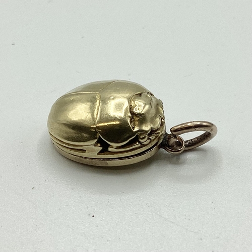 19 - An unmarked yellow metal (possibly 14ct+ gold) scarab beetle memorial locket. Opening to reveal oval... 