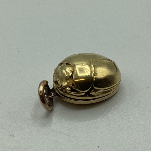 19 - An unmarked yellow metal (possibly 14ct+ gold) scarab beetle memorial locket. Opening to reveal oval... 