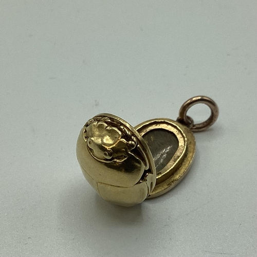 19 - An unmarked yellow metal (possibly 14ct+ gold) scarab beetle memorial locket. Opening to reveal oval... 