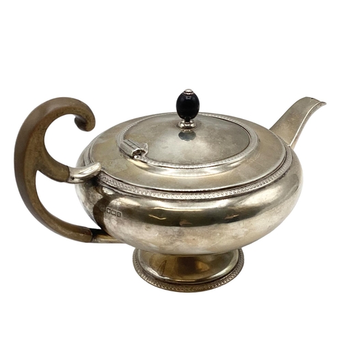 21 - A sterling silver tea pot of bulbous form with fruit wood handle by John Roberts, Sheffield. 1912. 5... 