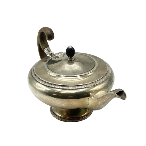 21 - A sterling silver tea pot of bulbous form with fruit wood handle by John Roberts, Sheffield. 1912. 5... 