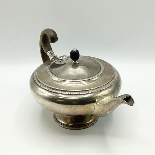 21 - A sterling silver tea pot of bulbous form with fruit wood handle by John Roberts, Sheffield. 1912. 5... 