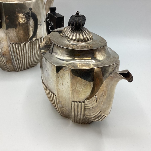 22 - A sterling silver two piece tea set with half reeded design and ebonised handle. Approx 32ozt Sheffi... 