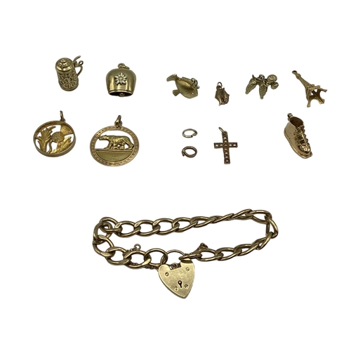 28 - A 9 ct gold flat link charm bracelet with A 9ct gold heart locket together with 10 9 ct gold and unm... 