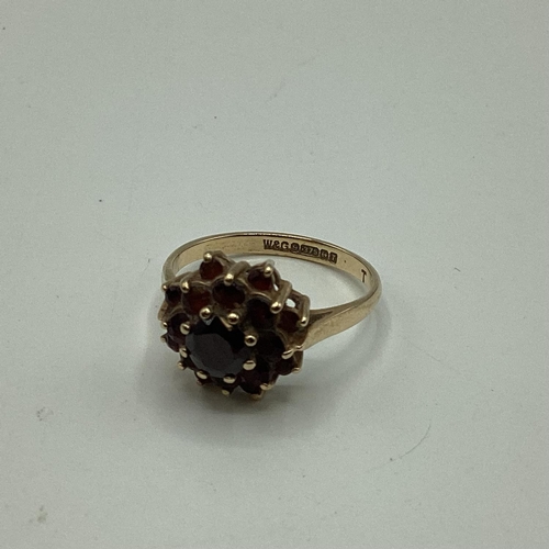 31 - A 9 ct gold garnet set flower ring together with unmarked yellow metal garnet set four stone ring an... 