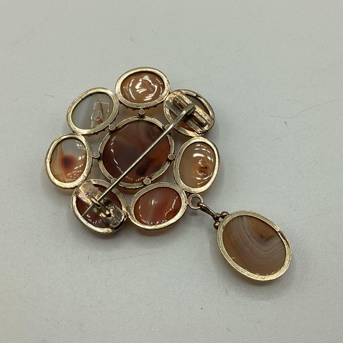 38 - An unmarked yellow metal Scottish hardstone flower brooch set with 9 agate hardstones. 14.3g.