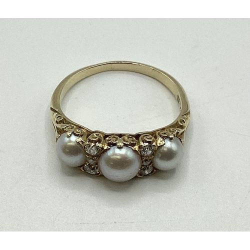 39 - An 18 ct gold pearl and diamond set ring, 3 half pearls with old cut diamond separators to a scrolli... 