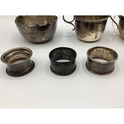 44 - A collection of 8 sterling silver items to include christening cup, sugar bowl, napkin rings and spo... 