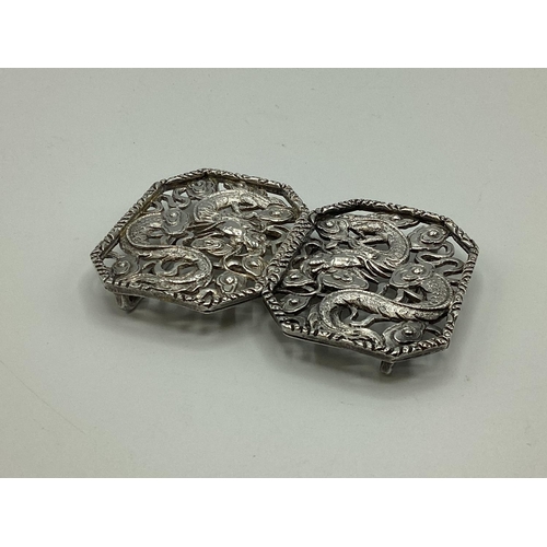 49 - A Chinese silver two part buckle with stylised dragon decoration by Hung Chong and CO Hong Kong circ... 