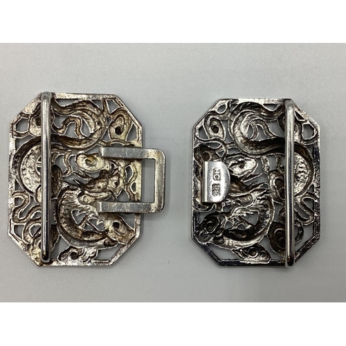 49 - A Chinese silver two part buckle with stylised dragon decoration by Hung Chong and CO Hong Kong circ... 