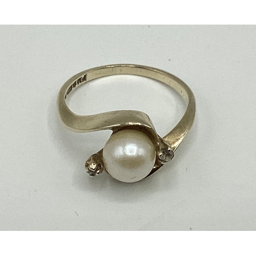 56 - A 9ct gold pearl and diamond set ring. Central pearl with diamond accents. 2.56g. Size M.