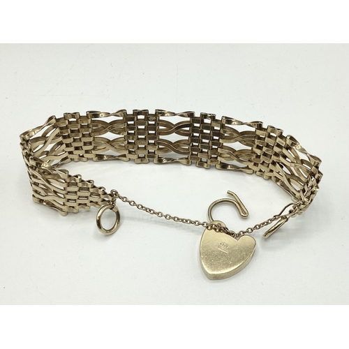 6 - A 9ct gold flat gate link bracelet with 9ct gold heart locket. 25.80g.