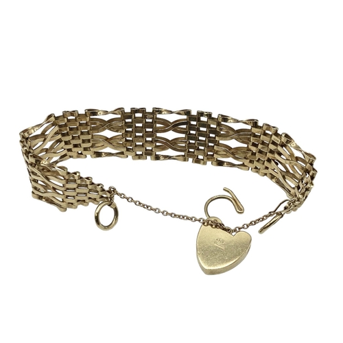 6 - A 9ct gold flat gate link bracelet with 9ct gold heart locket. 25.80g.