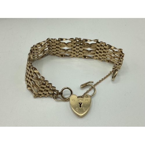 6 - A 9ct gold flat gate link bracelet with 9ct gold heart locket. 25.80g.