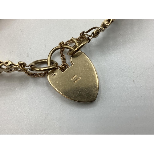 6 - A 9ct gold flat gate link bracelet with 9ct gold heart locket. 25.80g.