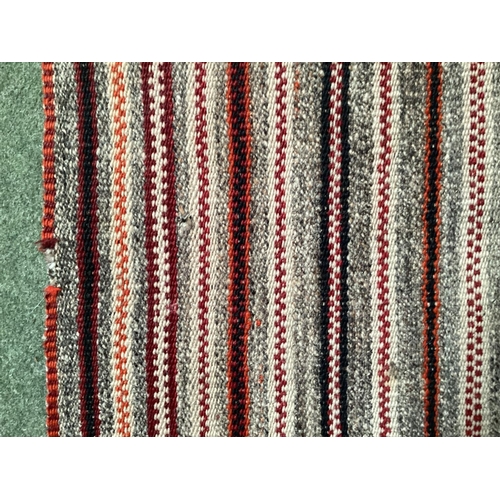 639 - A Kilim style rug/runner with all over stylized reds and greys stripes, 133/310cm