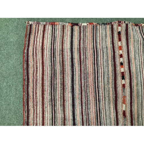 639 - A Kilim style rug/runner with all over stylized reds and greys stripes, 133/310cm