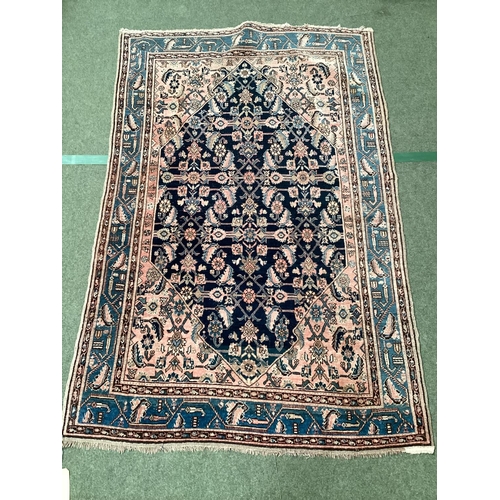 640 - A Persian style rug, with blue border, and central medallion of dark blue ground with pink/cream and... 