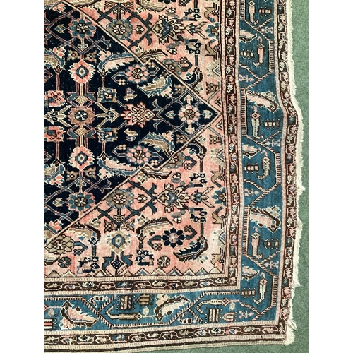 640 - A Persian style rug, with blue border, and central medallion of dark blue ground with pink/cream and... 