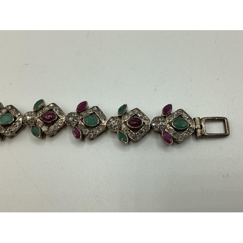 65 - A suite of South Asian style white metal jewellery, ruby, emerald and diamond set, bracelet 21 cm, n... 