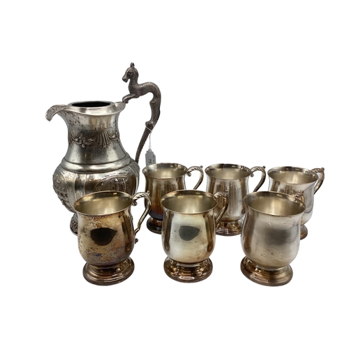 75 - A collection of 6 silver plated mugs together with a silver plated water jug with embossed decoratio... 