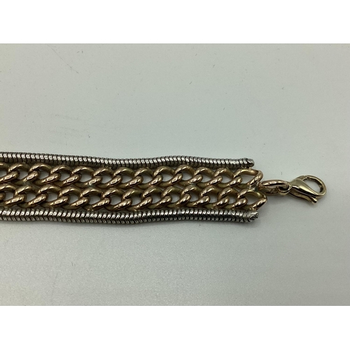 8 - A 9ct yellow and white gold flat belt link bracelet. Approx 17cm. 32g.