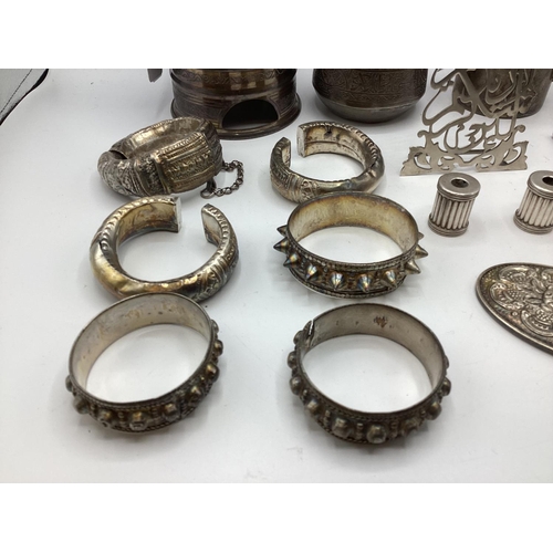 80 - A collection of Middle Eastern silver and white metal items to include ornamental water jugs, bangle... 