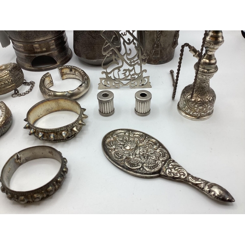 80 - A collection of Middle Eastern silver and white metal items to include ornamental water jugs, bangle... 