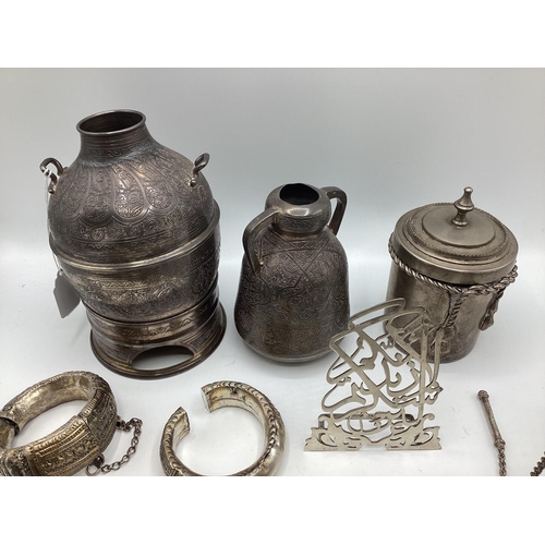 80 - A collection of Middle Eastern silver and white metal items to include ornamental water jugs, bangle... 