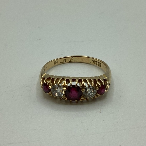 95 - An 18 carat gold Ruby and diamond ring, 3 round free cut rubies set with two old cut diamonds, 3g  s... 