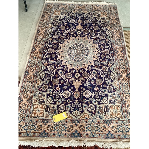 598 - A Persian wool rug,  blue and beige ground, with central star medallion, 114cm x 215cm, cleared from... 