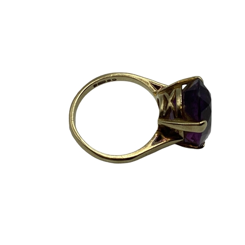 11 - A 9ct gold and amethyst dress ring. Central  oval free cut amethyst, Approx 17mm x 12mm in a four cl... 