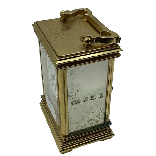 31 - A sterling silver panelled electric carriage clock. Gilt metal case with three sterling silver panel... 