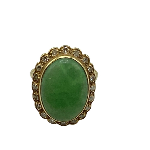 8 - An unmarked yellow metal jade and diamond dress ring, central oval jade cabochon with a surround of ... 