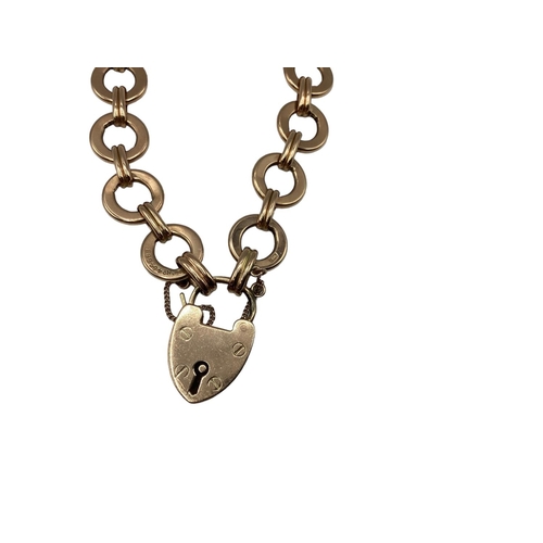 82 - A 9ct rose gold fancy link bracelet with heart locket. 7.10g.