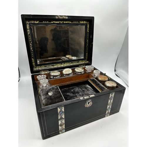 53 - An ebonised wooden and abalone and mother of pearl inlaid travelling case, opening to reveal mirrore... 