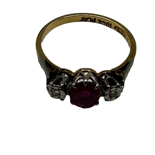 68 - An 18ct gold and platinum ring. Central oval free cut ruby with illusion set diamond accents. Size L... 