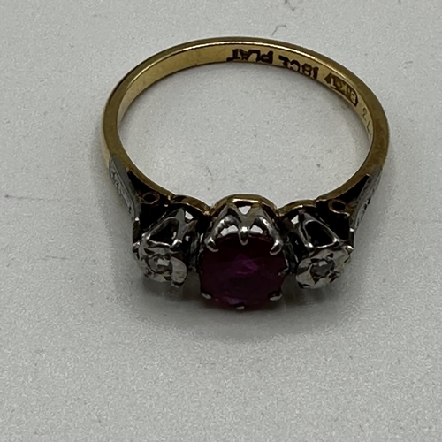 68 - An 18ct gold and platinum ring. Central oval free cut ruby with illusion set diamond accents. Size L... 