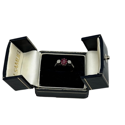 68 - An 18ct gold and platinum ring. Central oval free cut ruby with illusion set diamond accents. Size L... 