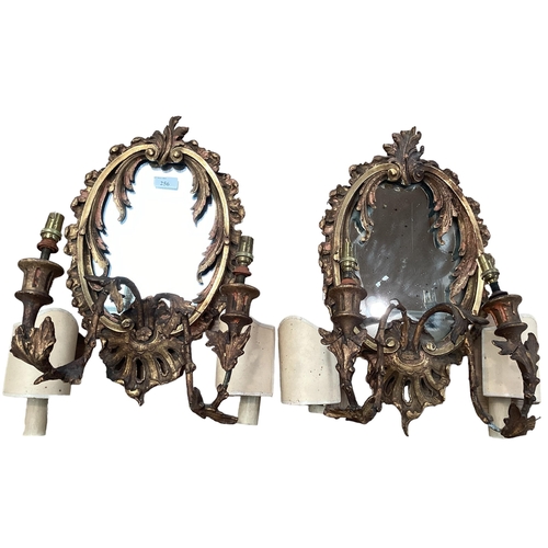 256 - A pair of oval sconces, with mirrored back and ornate floral carved gesso surround, 39cm High overal... 