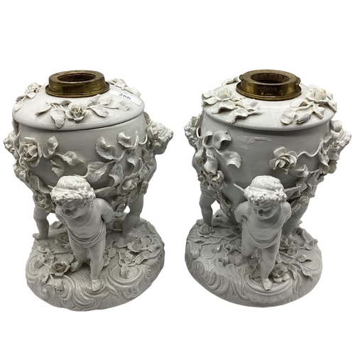 266 - A pair of Moore Bros, cherub stands, 24cm H, some losses