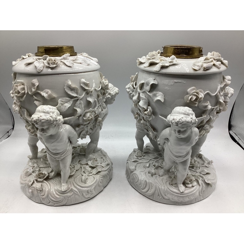 266 - A pair of Moore Bros, cherub stands, 24cm H, some losses