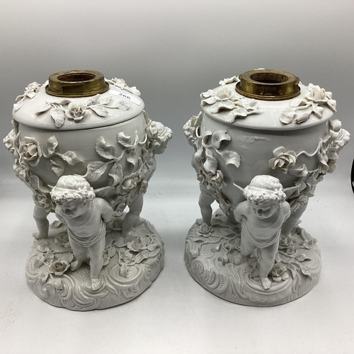 266 - A pair of Moore Bros, cherub stands, 24cm H, some losses