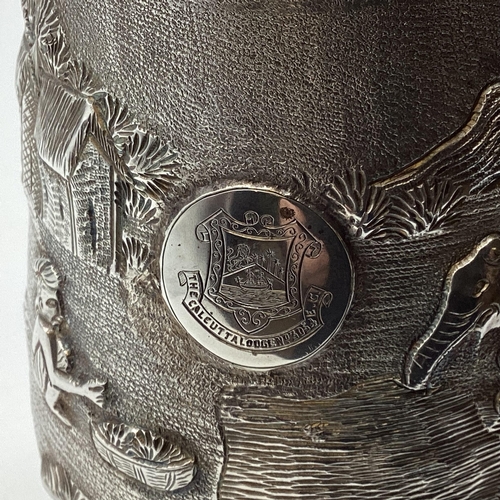 62 - A South Asian white metal mug with country scenes and elephants. Engraved from 'The Calcutta Lodge'.... 