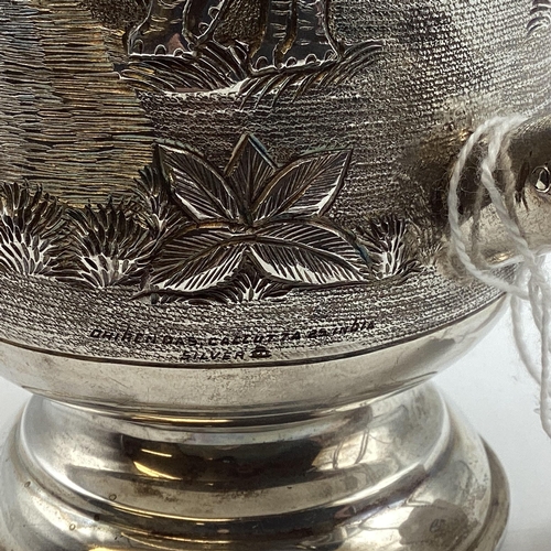 62 - A South Asian white metal mug with country scenes and elephants. Engraved from 'The Calcutta Lodge'.... 